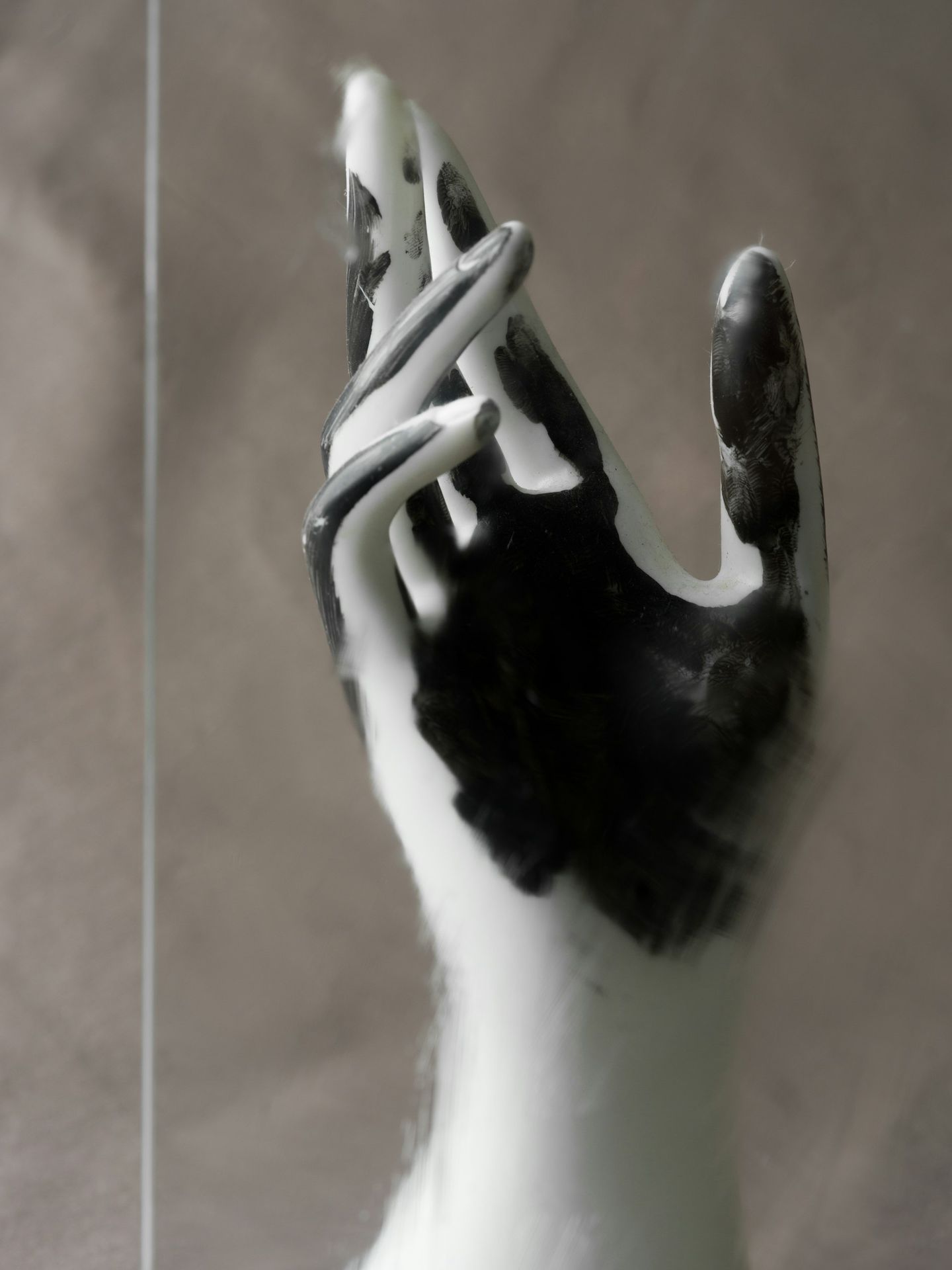 A mannequin hand with black and white paint streaks.